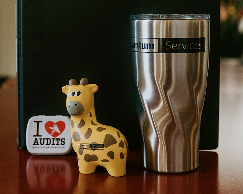 Quantum Services Audits Quantum giraffe with coffee mug and sticker